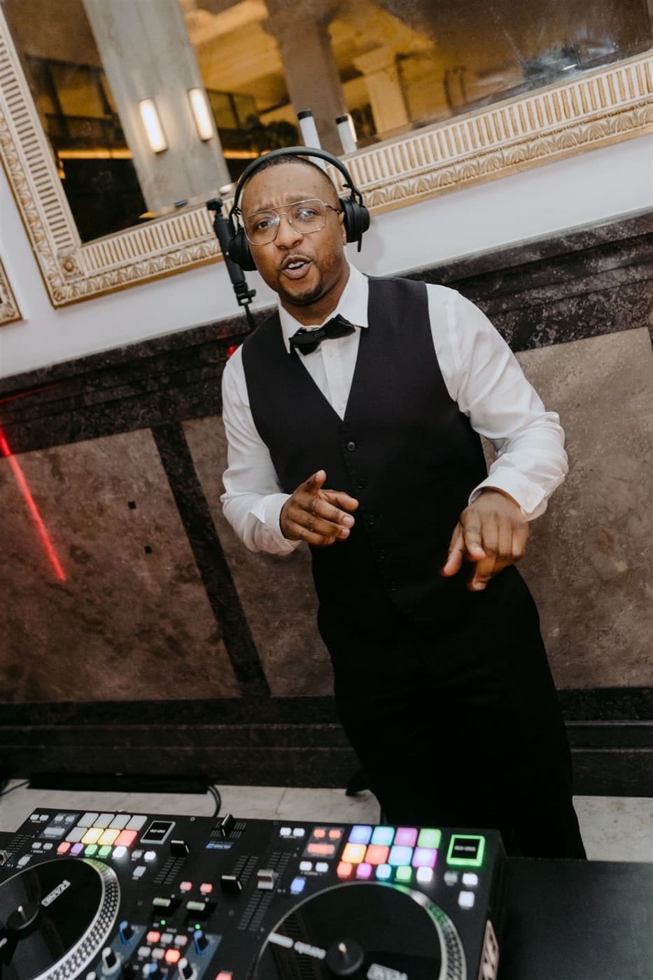 Dan Alex, Myla's founder, DJing a wedding in headphones and a waistcoat
